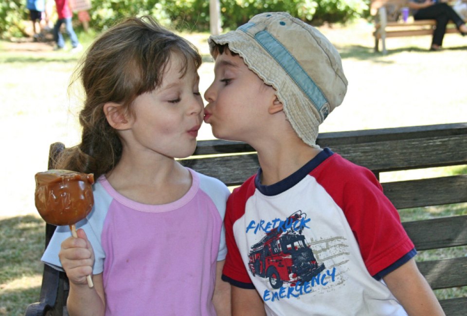 Two kids share a caramel apple. Photo by Meghan Rose